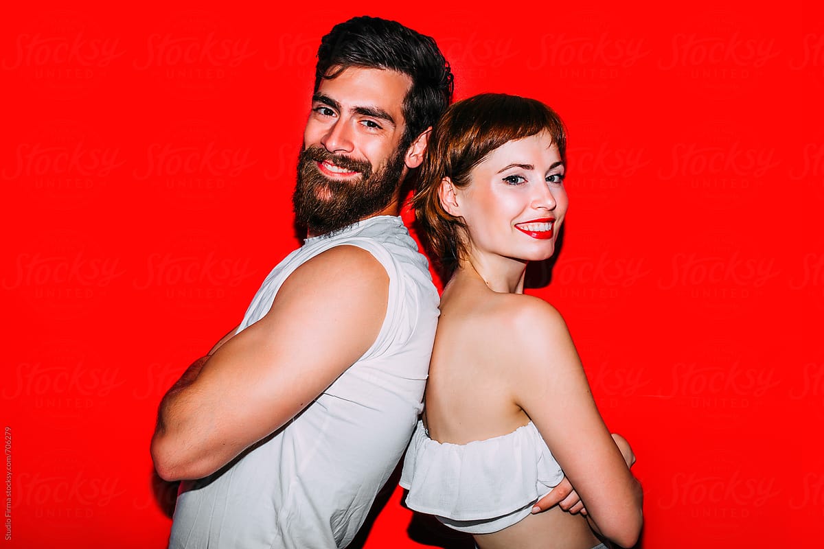 Young Love Couple Having Fun In Front Of The Red Background Del Colaborador De Stocksy 4083