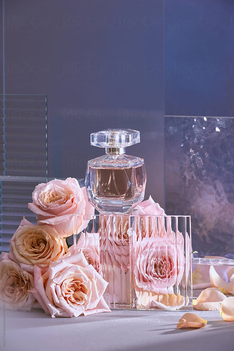 Perfume on podium, made of glass with roses on dark