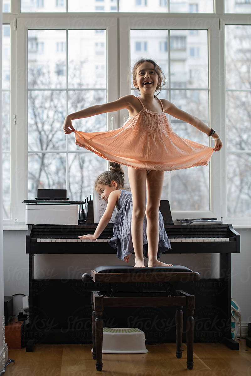 Little girls posing on a piano chair