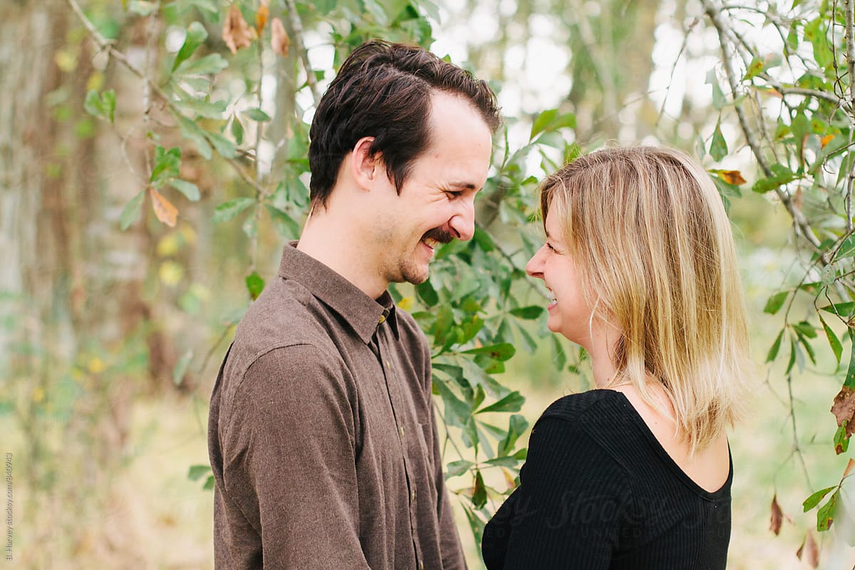 Cute Couple Laughing and Smiling Surrounded by Tree Branches
