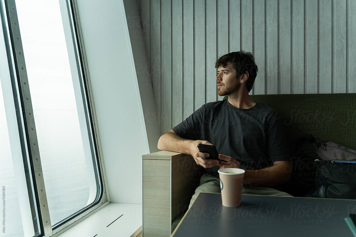 Man traveling by ferry using phone