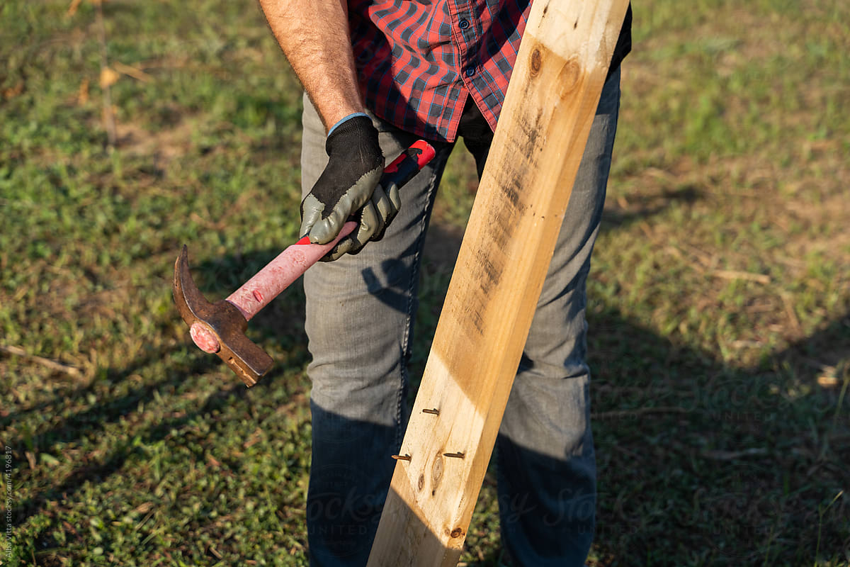 Crop image of Man removing nails from pallet outdoors