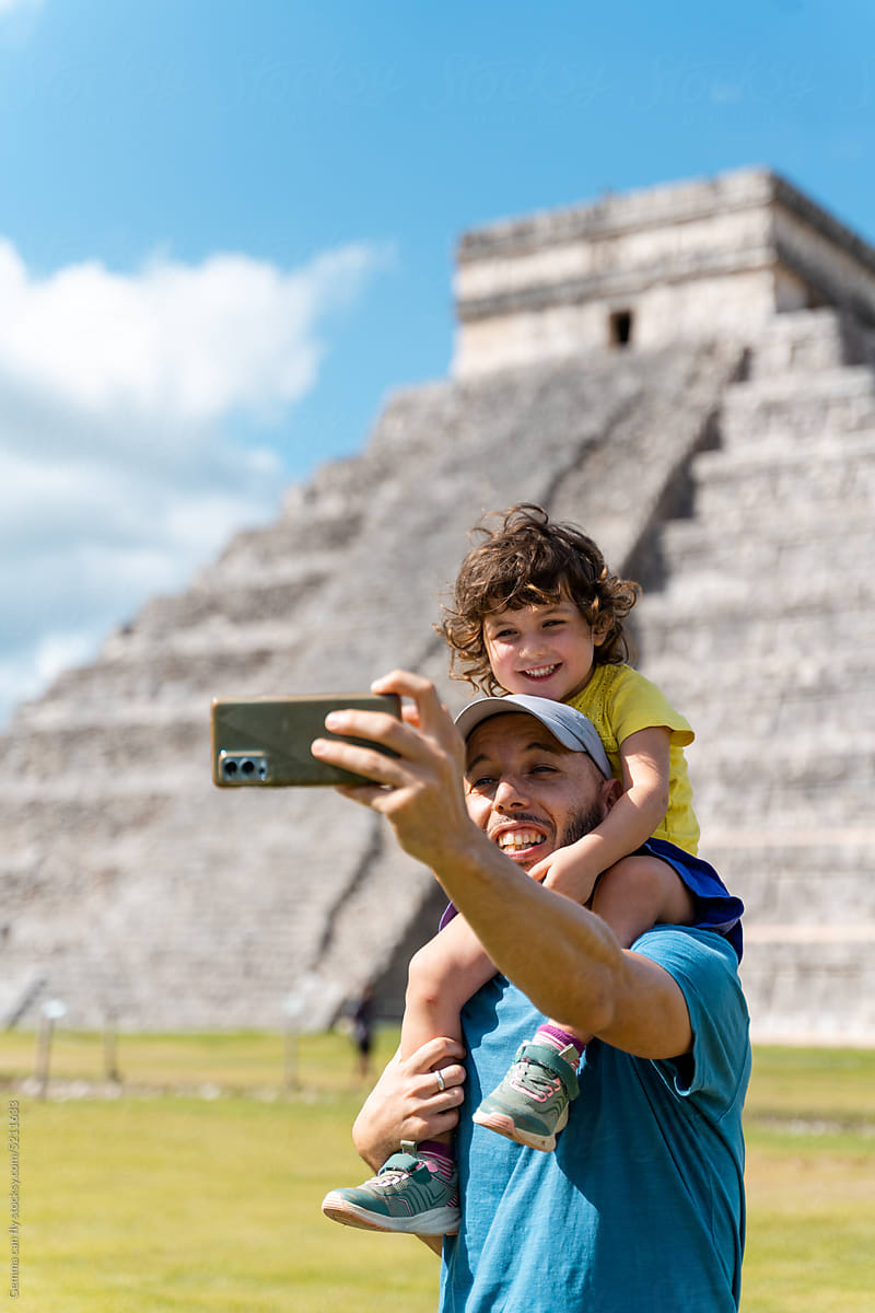 Father and daughter taking a selfie photo in Chichen Itzá, Mexico