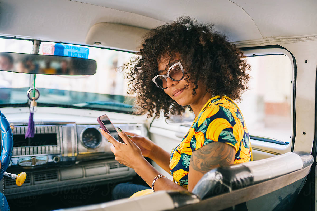 A female passenger in a car with a phone