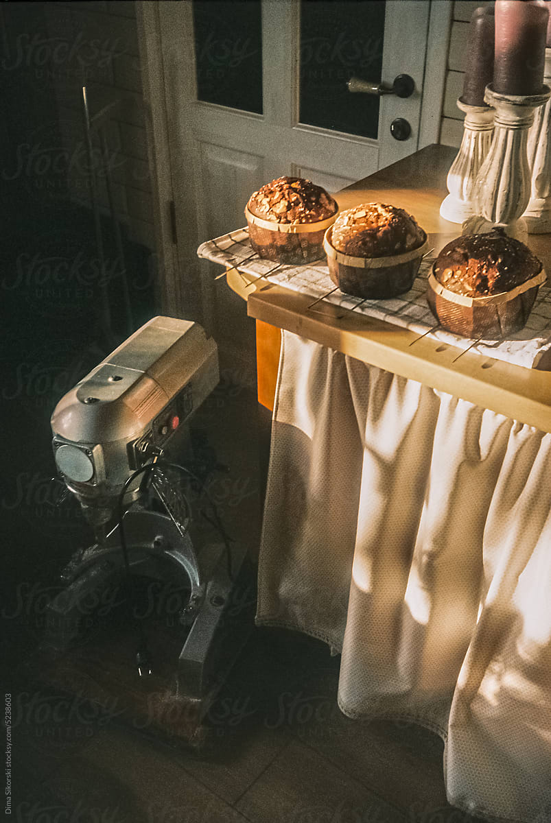 Freshly baked Easter cakes near a large mixer in a cozy light