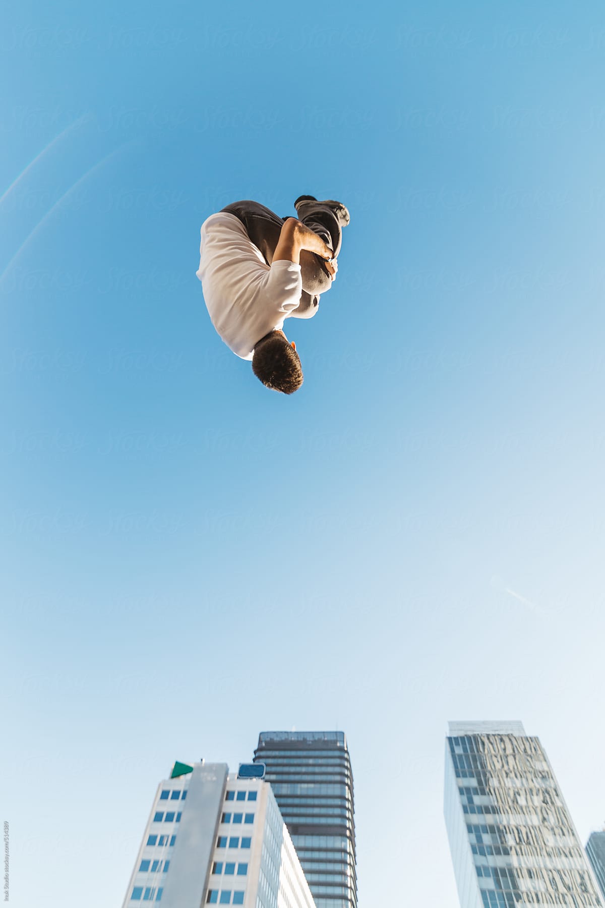 Low-angle photography of a man doing a somersault in the air