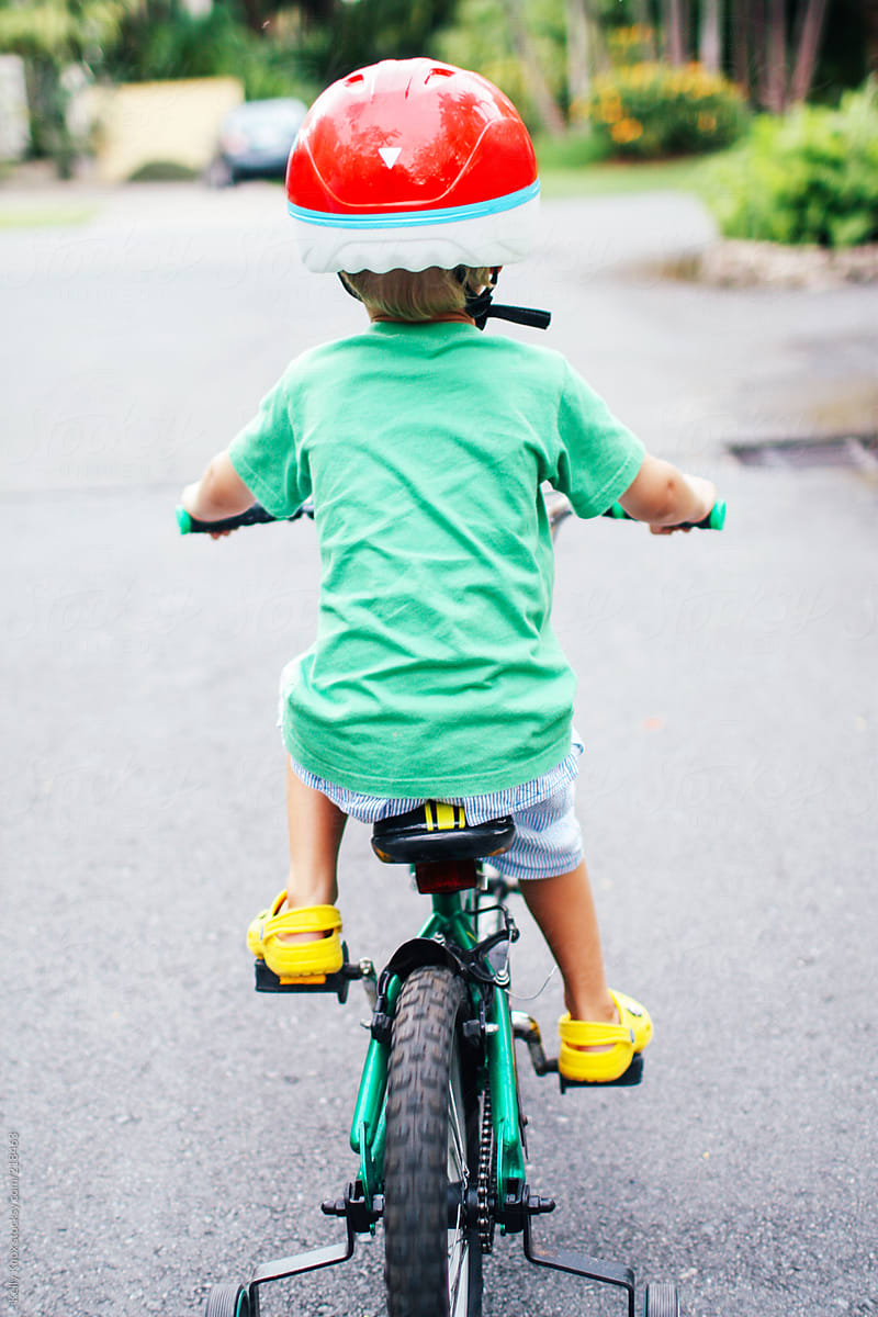 young child riding a bike with training wheels