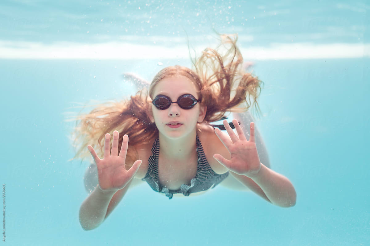 Girl Underwater Swimming Pressing Up Against A Glass Pool Wall By