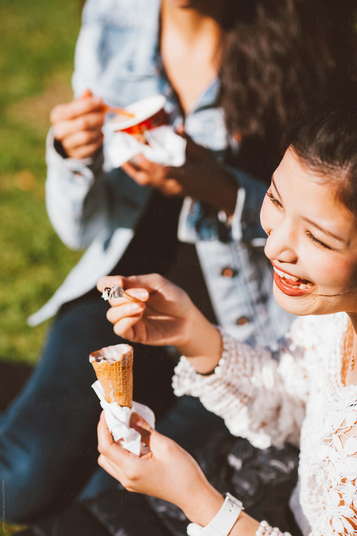 Mixed Race Girlfriends Eating Ice Cream While Having Fun Outdoors By Stocksy Contributor 0478