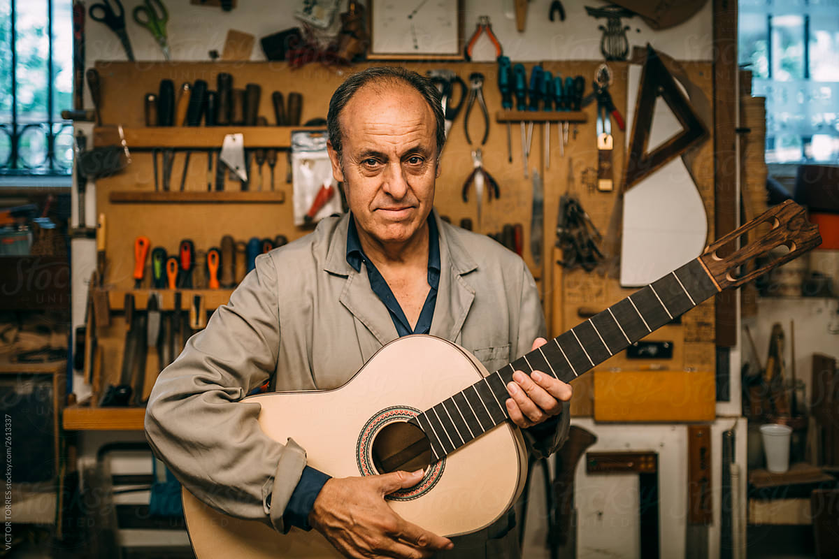 Portrait of senior man holding a custom spanish guitar