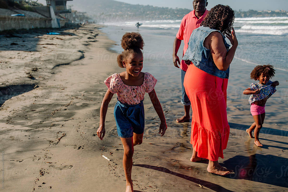 Black family wading at the beach