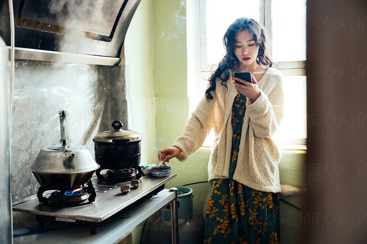 Young woman smoking in the kitchen