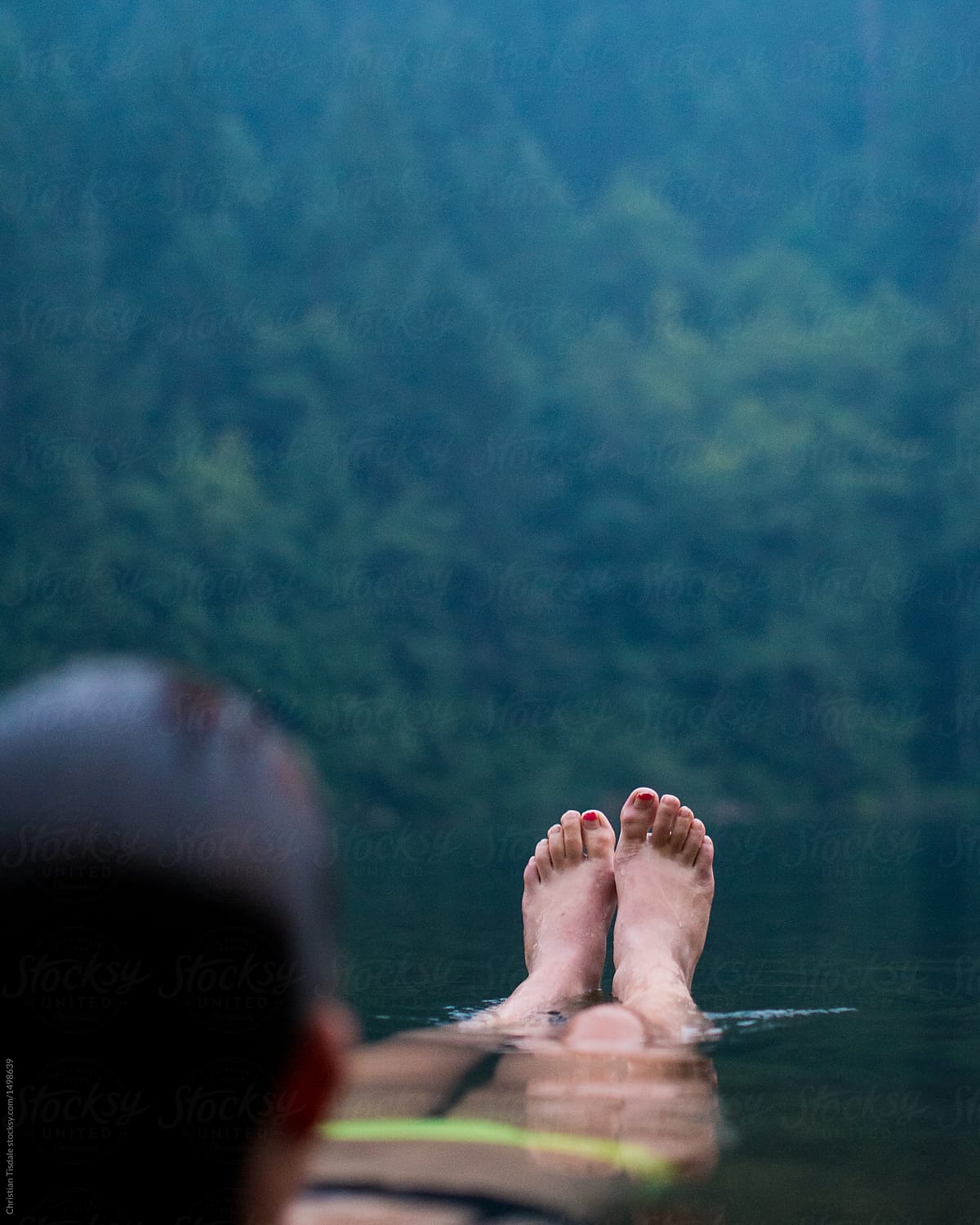 A Young Woman Floating In A Lake With Her Toes Out Of The Water In The  Evening by Stocksy Contributor Christian Tisdale - Stocksy
