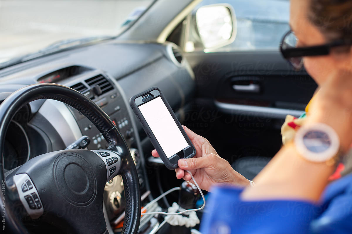 woman using smartphone with empty blank screen in car, hand with phone
