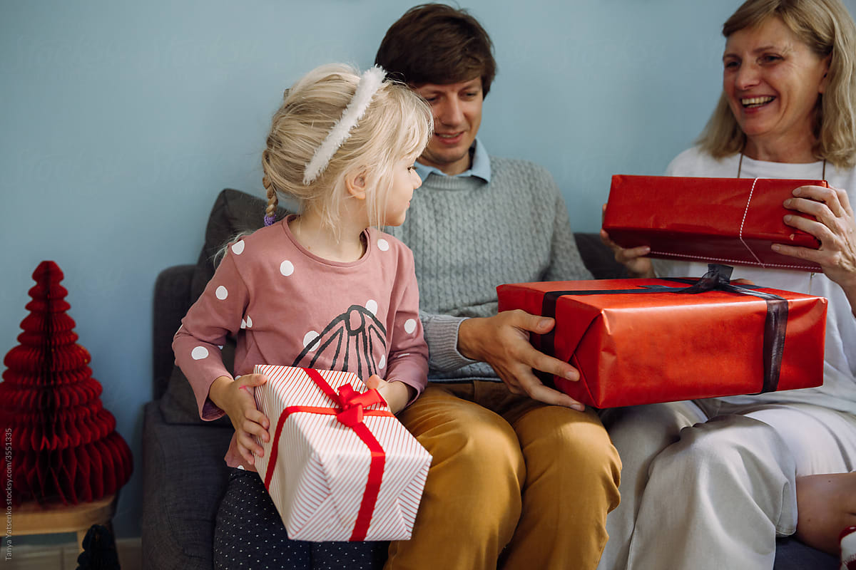A girl with her grandmother and father with wrapped presents