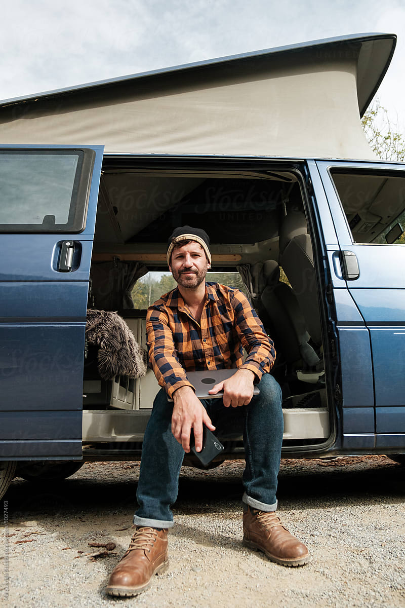Man looking at camera sitting in camper van