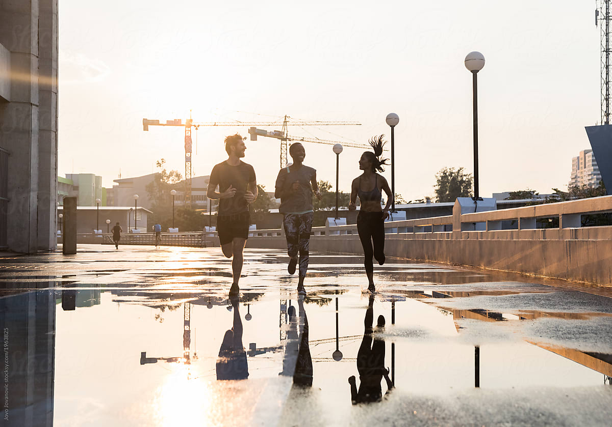 Three friends run in city after rain