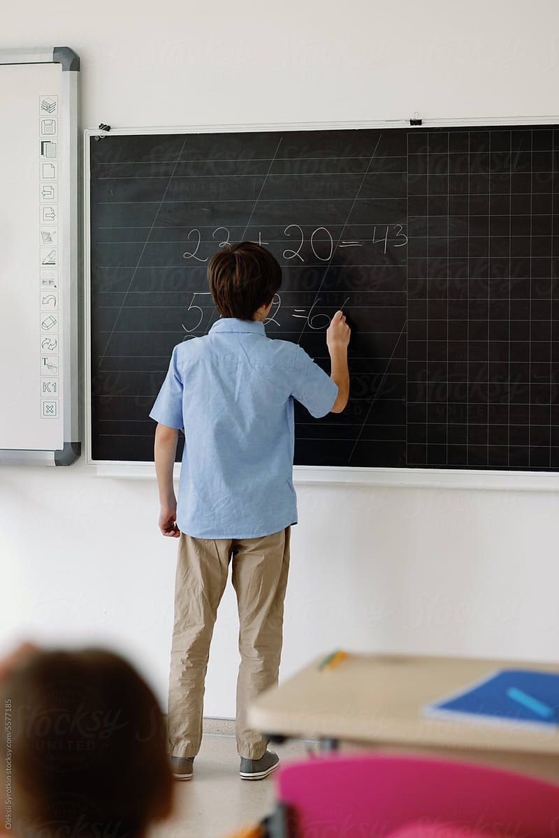 Intelligent pupil writing on blackboard