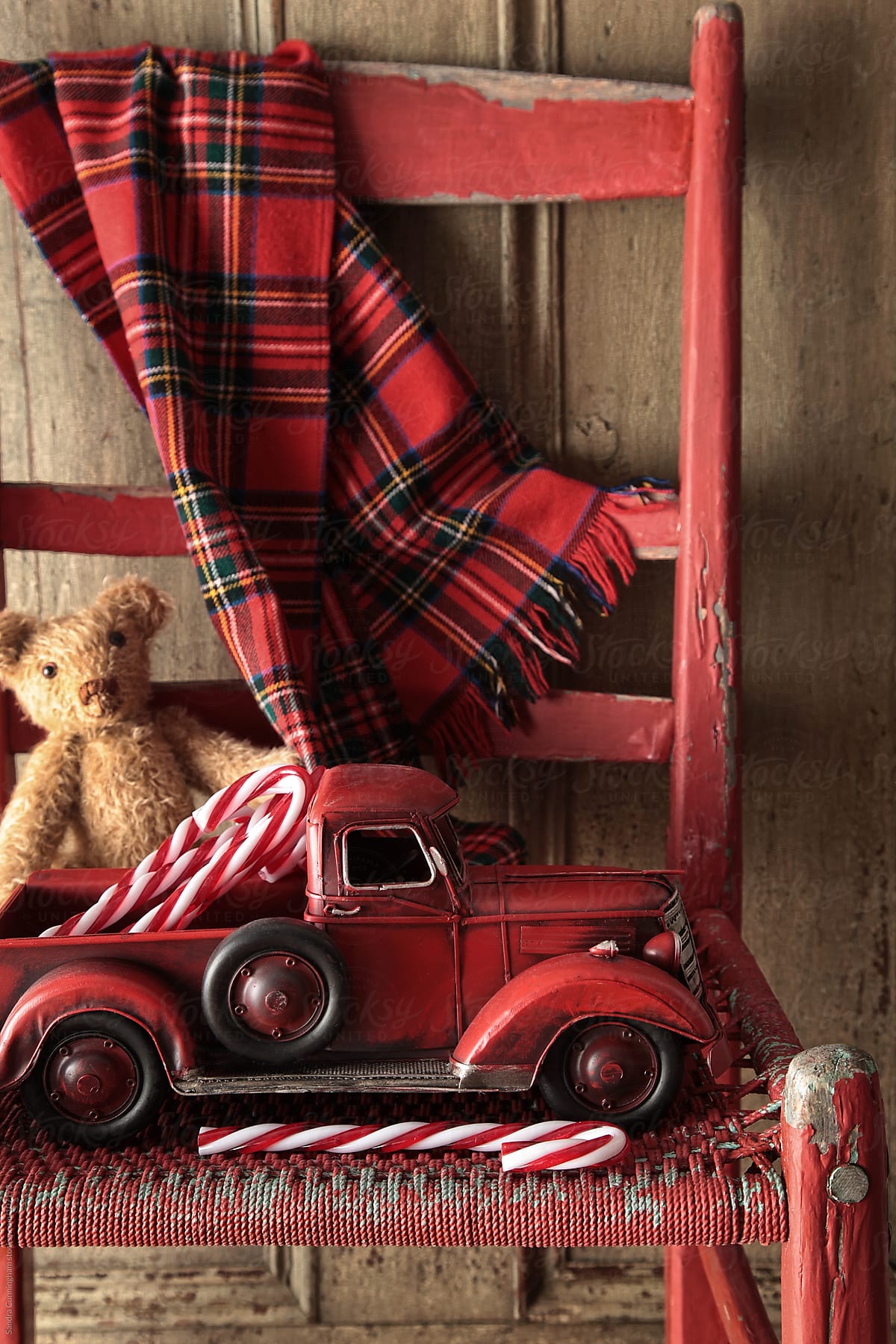 Old toy truck with teddy bear on red chair