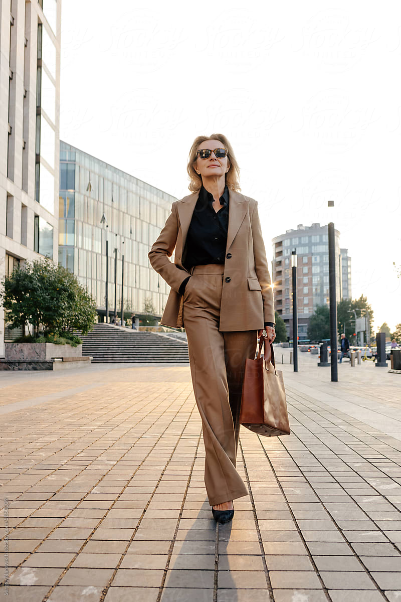 Woman in tan suit walking in city