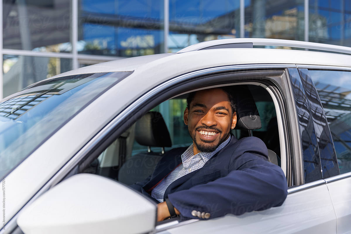 Portrait of smiling businessman sitting in new car