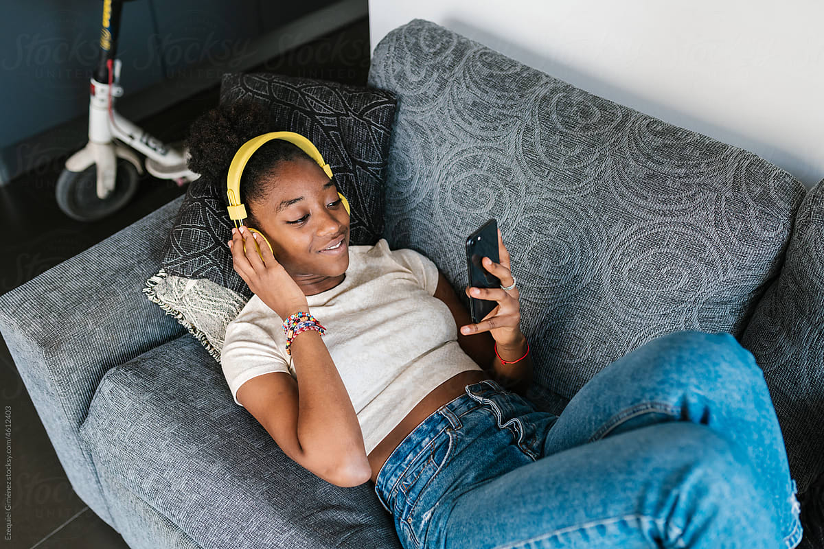 Young black female in headphones watching video