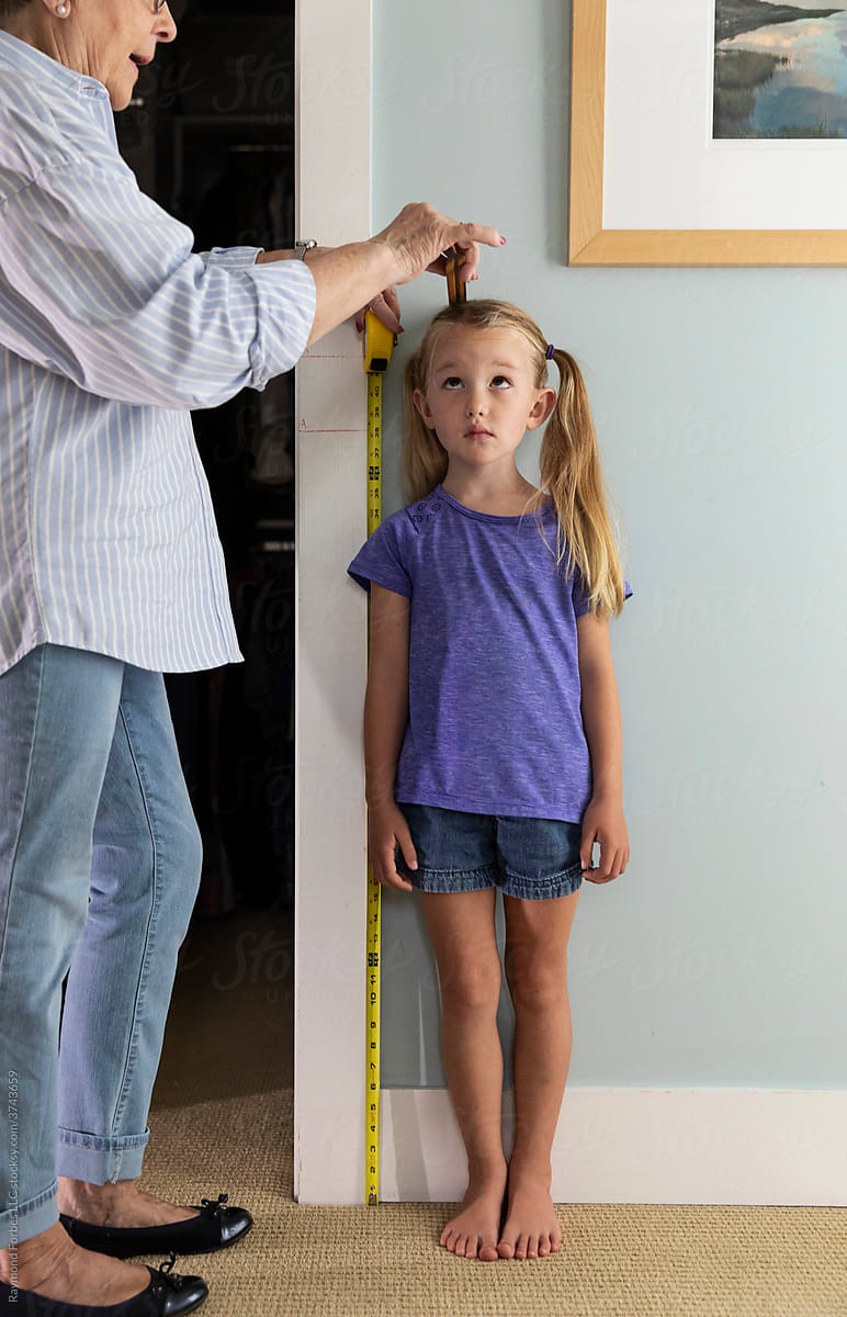 Shy Young Girl Measuring her height