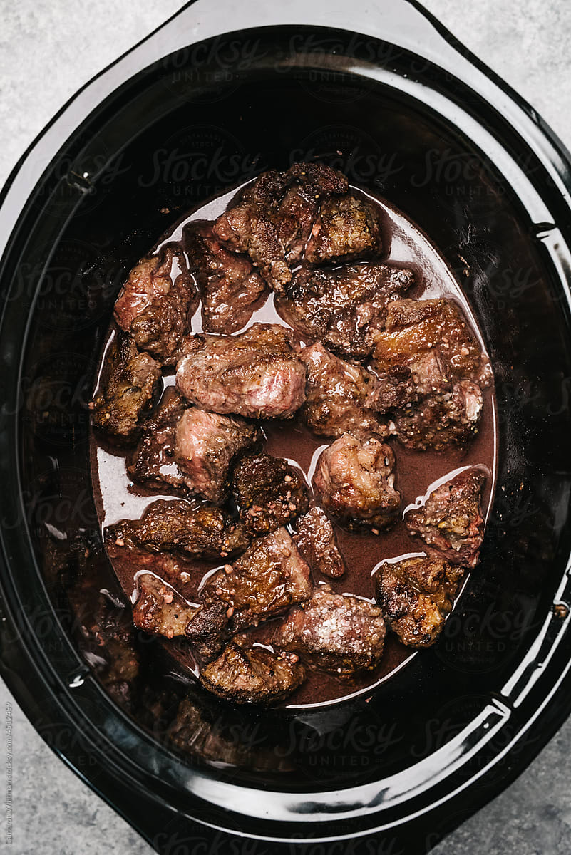 Chunks of beef cooking in a crockpot