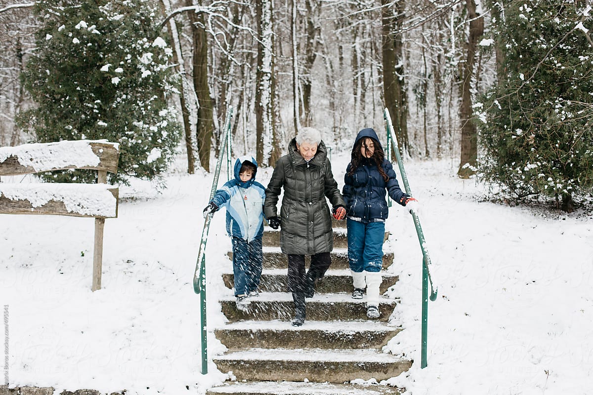 Grandma walking with grandchildren hands in hands in the Winter