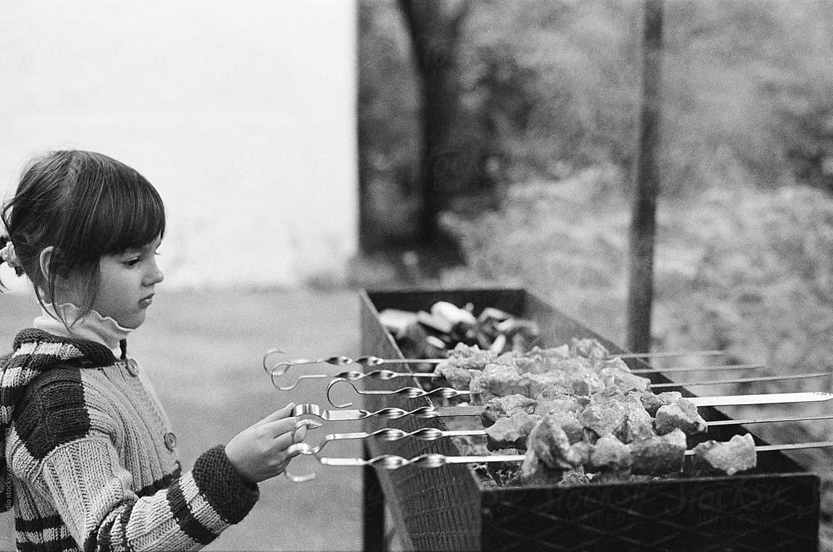 Little girl cooking barbecue