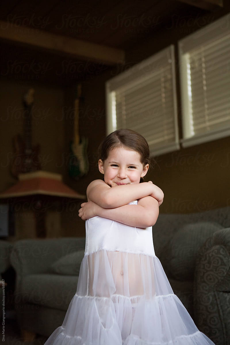 Little girl with crossed arms wearing white dress