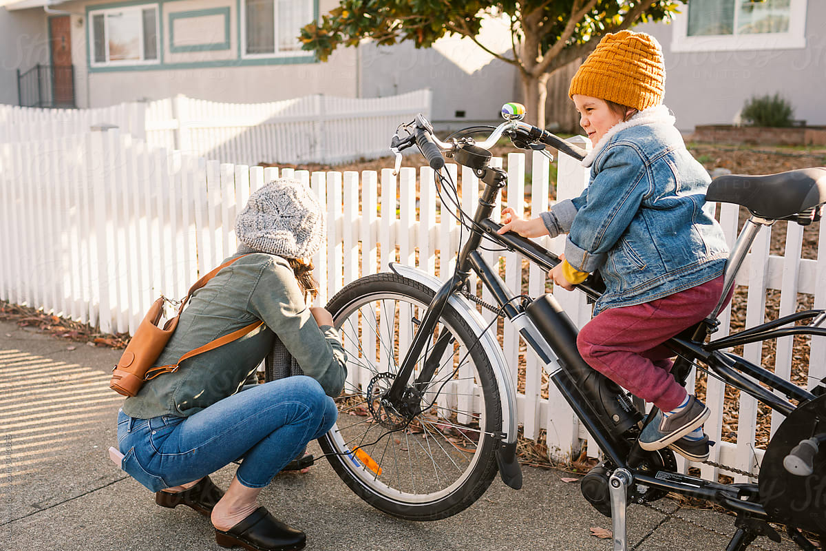 Mother and son preparing to ride a bike outside