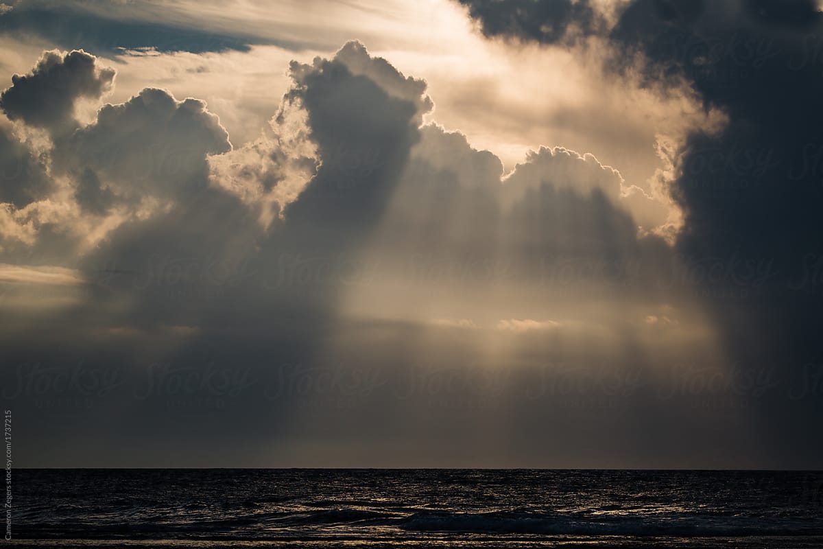 Sunlight breaking through the clouds over the ocean