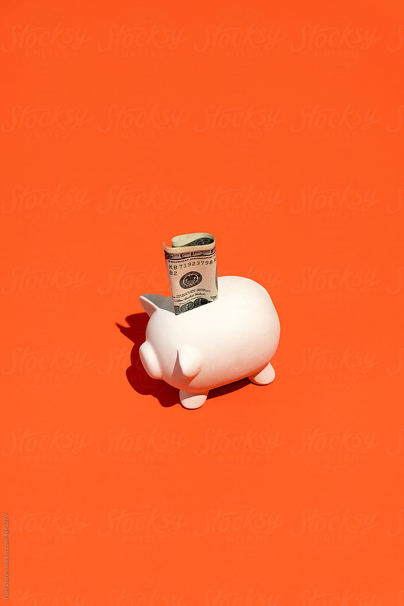 Piggy banks with a hundred dollar cash bill. Savings concept.