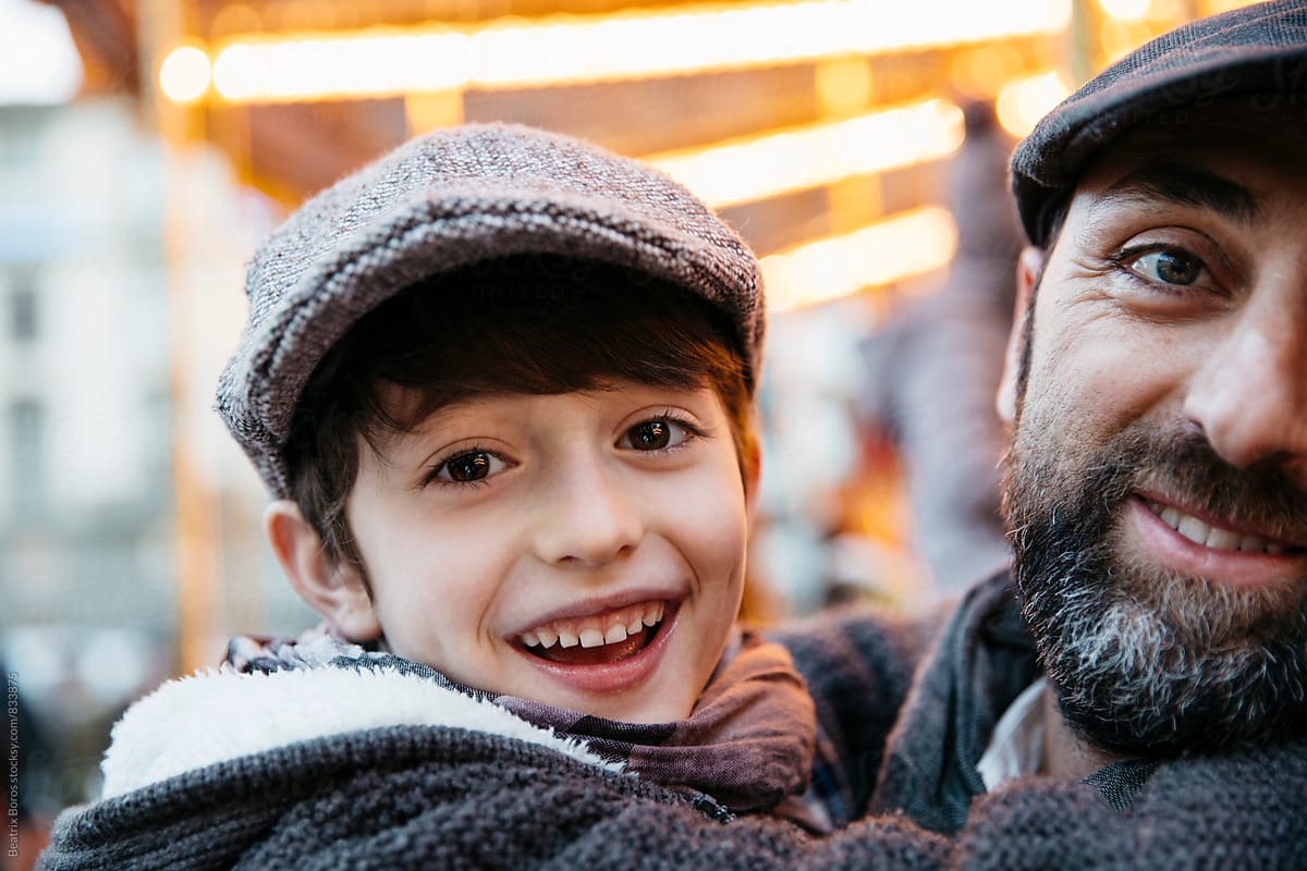 Father and son in front of golden carousel lights