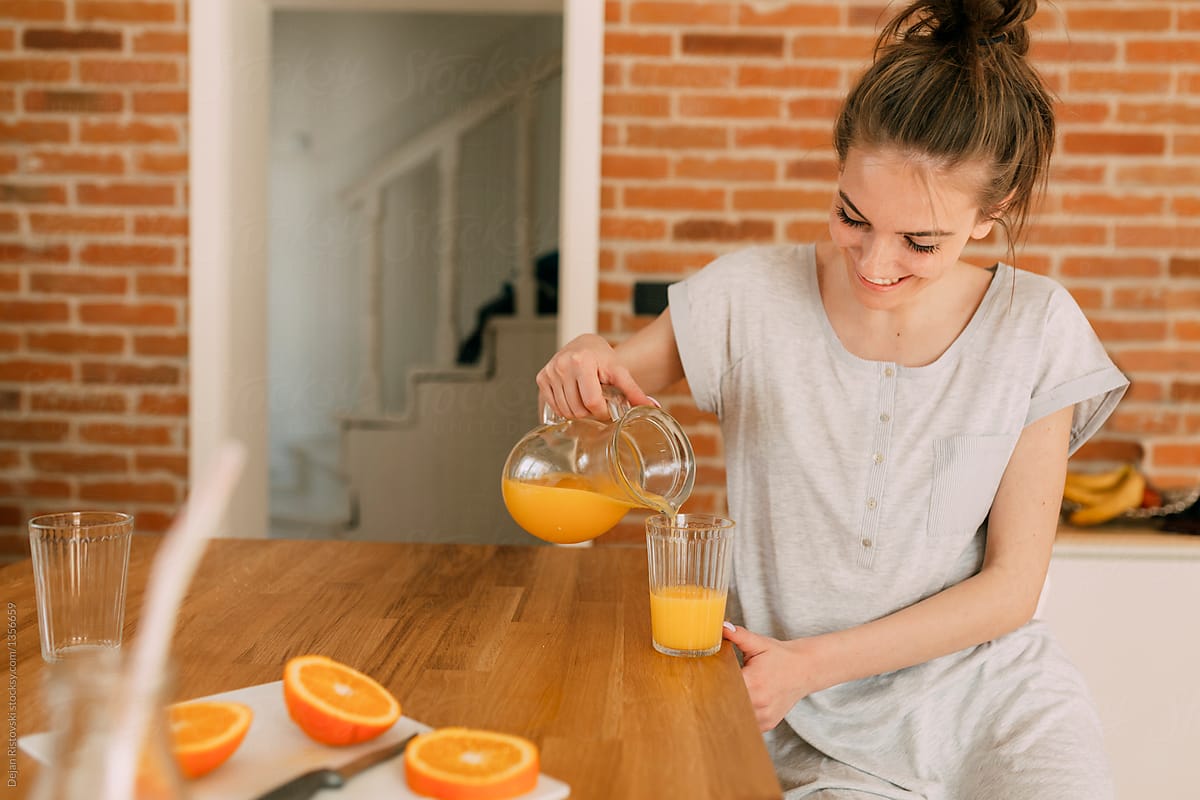 Girl taking an orange juice for breakfast.