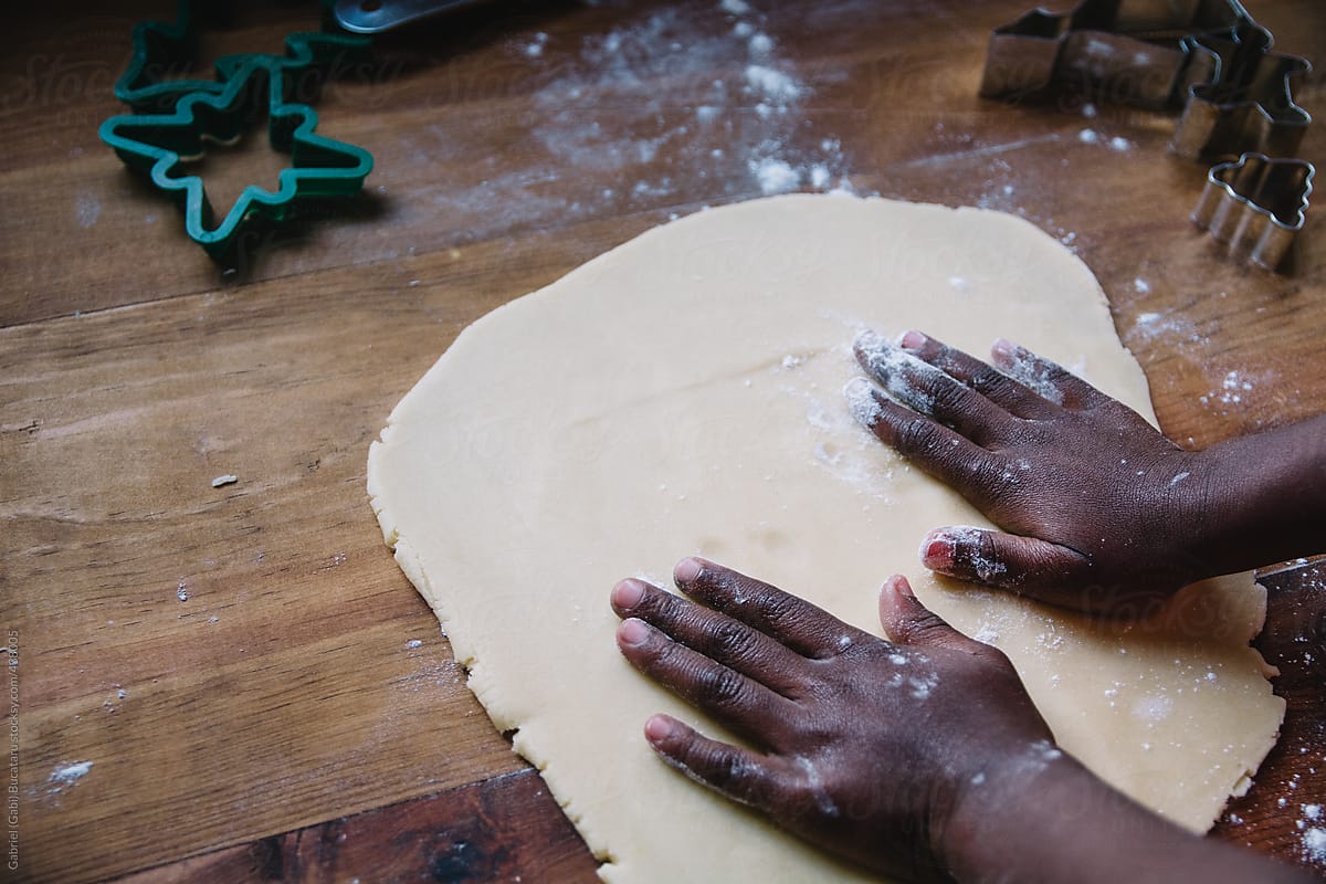 African American girl\'s hands on a rolled out cookie dough