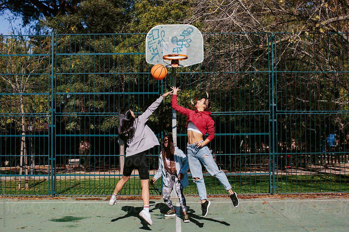 Three girls playing basketball