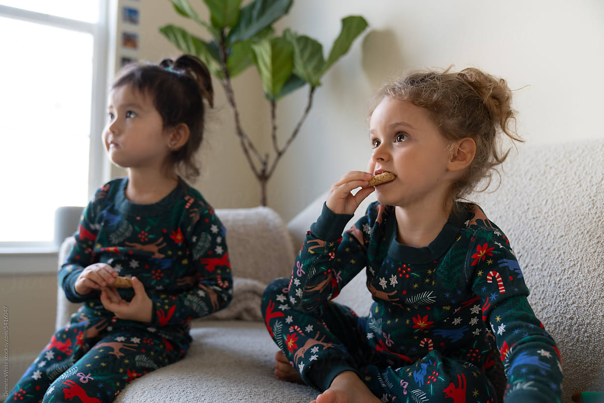 sisters eat cookies while watching TV