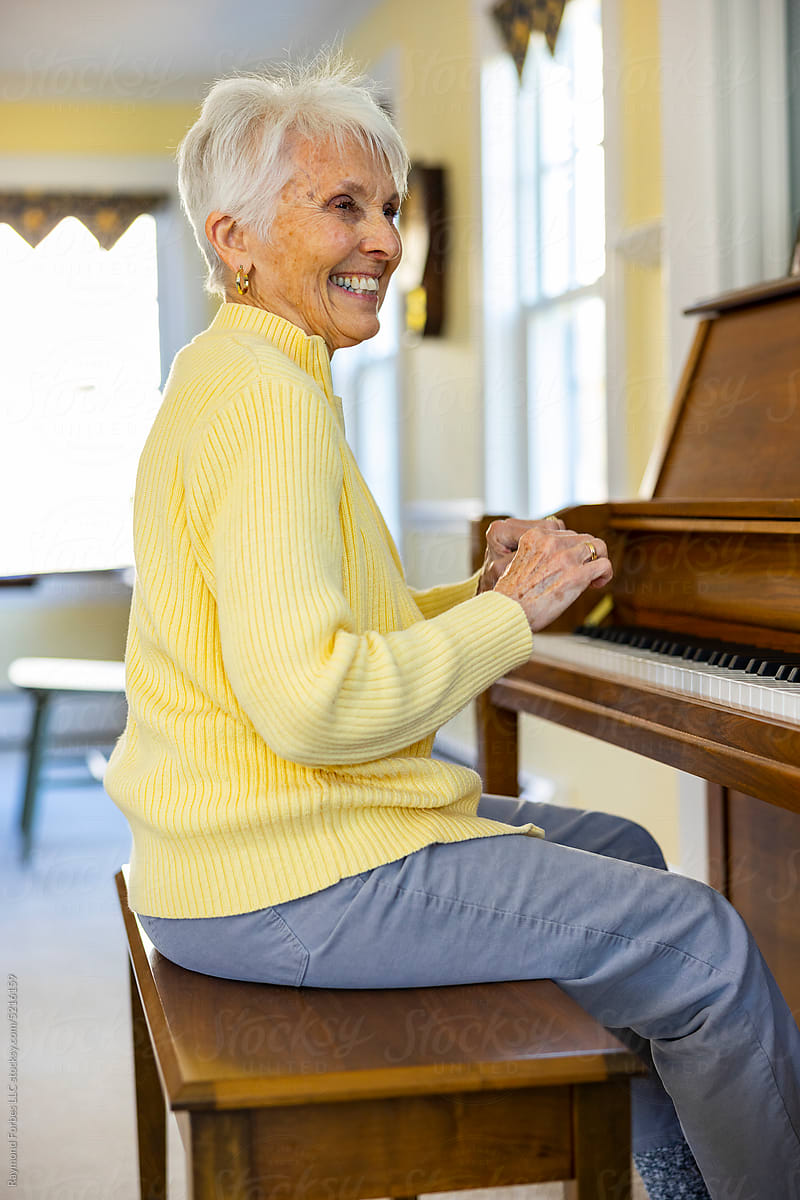 Portrait of Confident Senior Citizen woman at Home playing piano