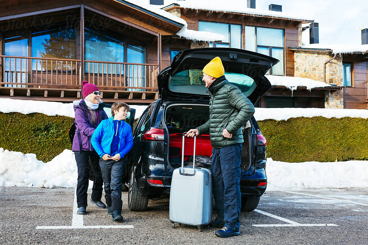 Grandparents and grandson on parking lot on winter day on resort