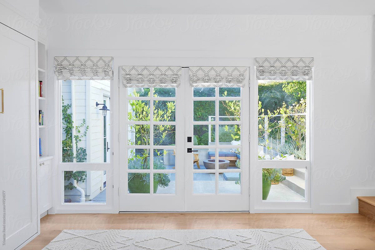 French doors with shades to patio in cottage home