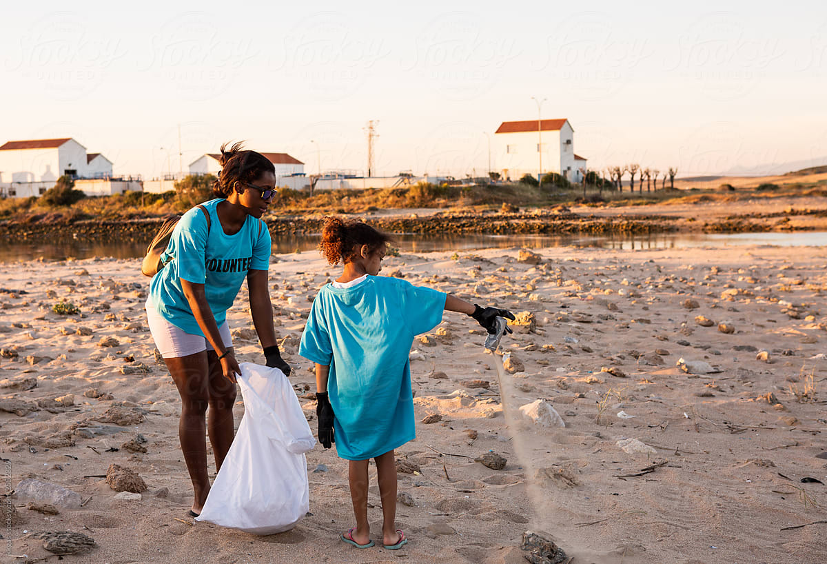 Small girl joining in with beach clean