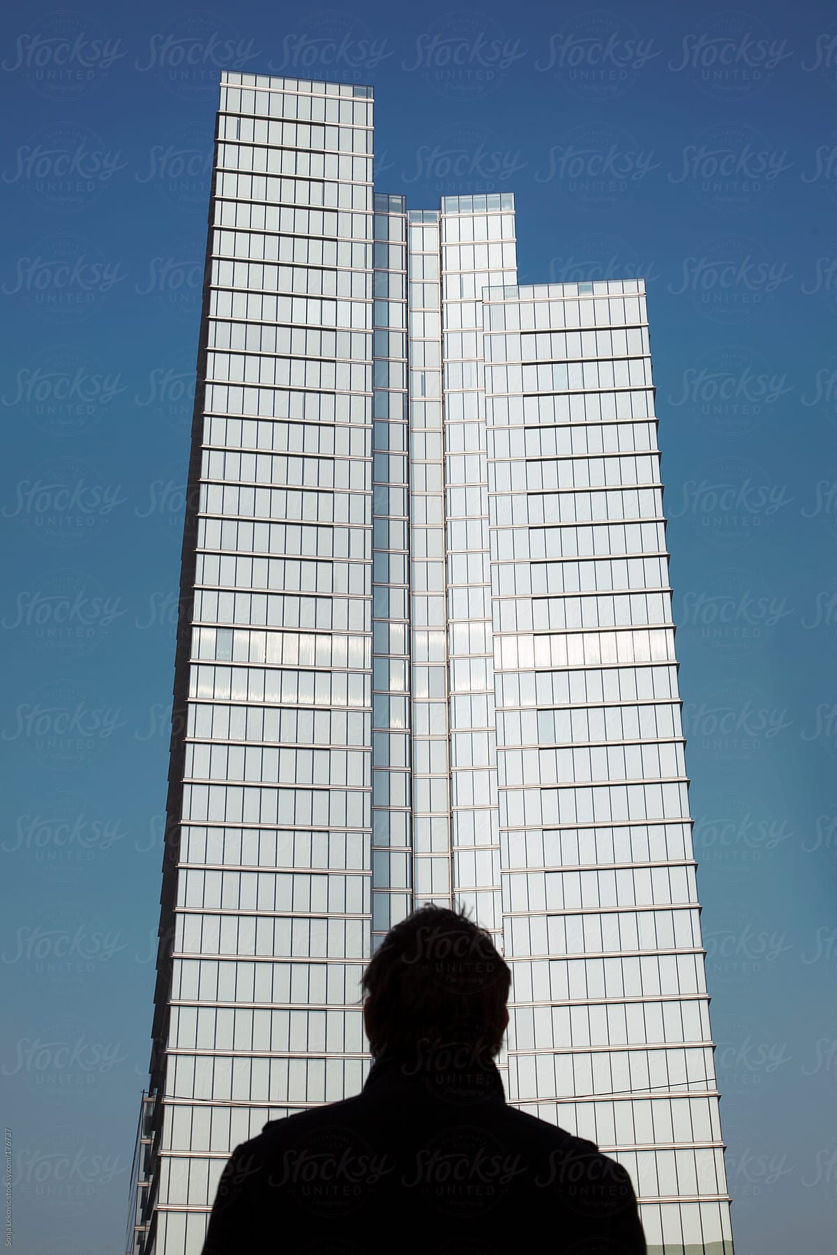 man looking at a high office building