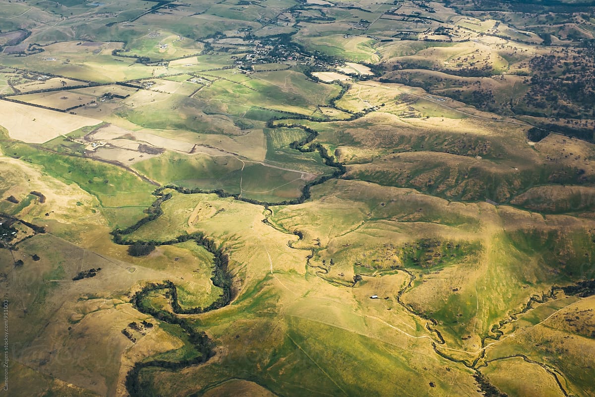 aerial view of stream winding through farmland