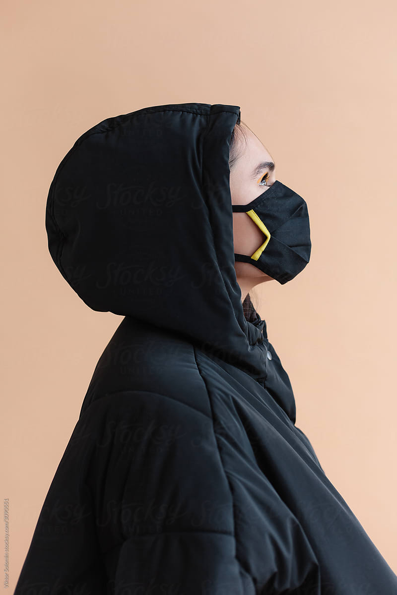 Studio closeup of woman wearing mask and winter coat