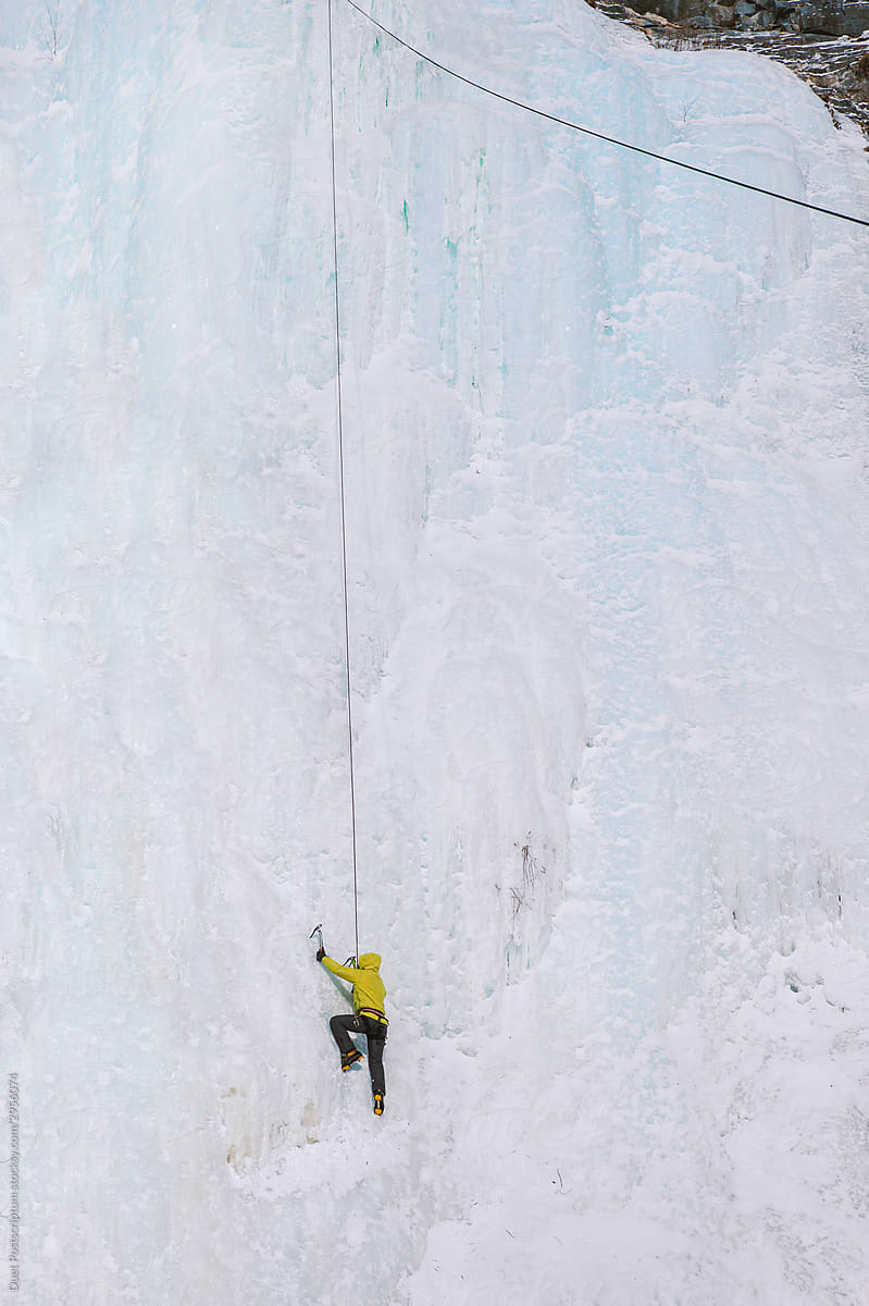 Climber climbs on a frozen waterfall