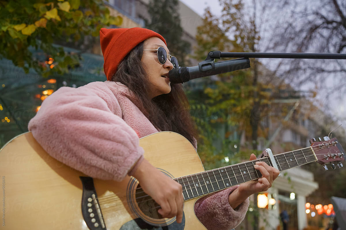 Asian female singer performing live concert on street