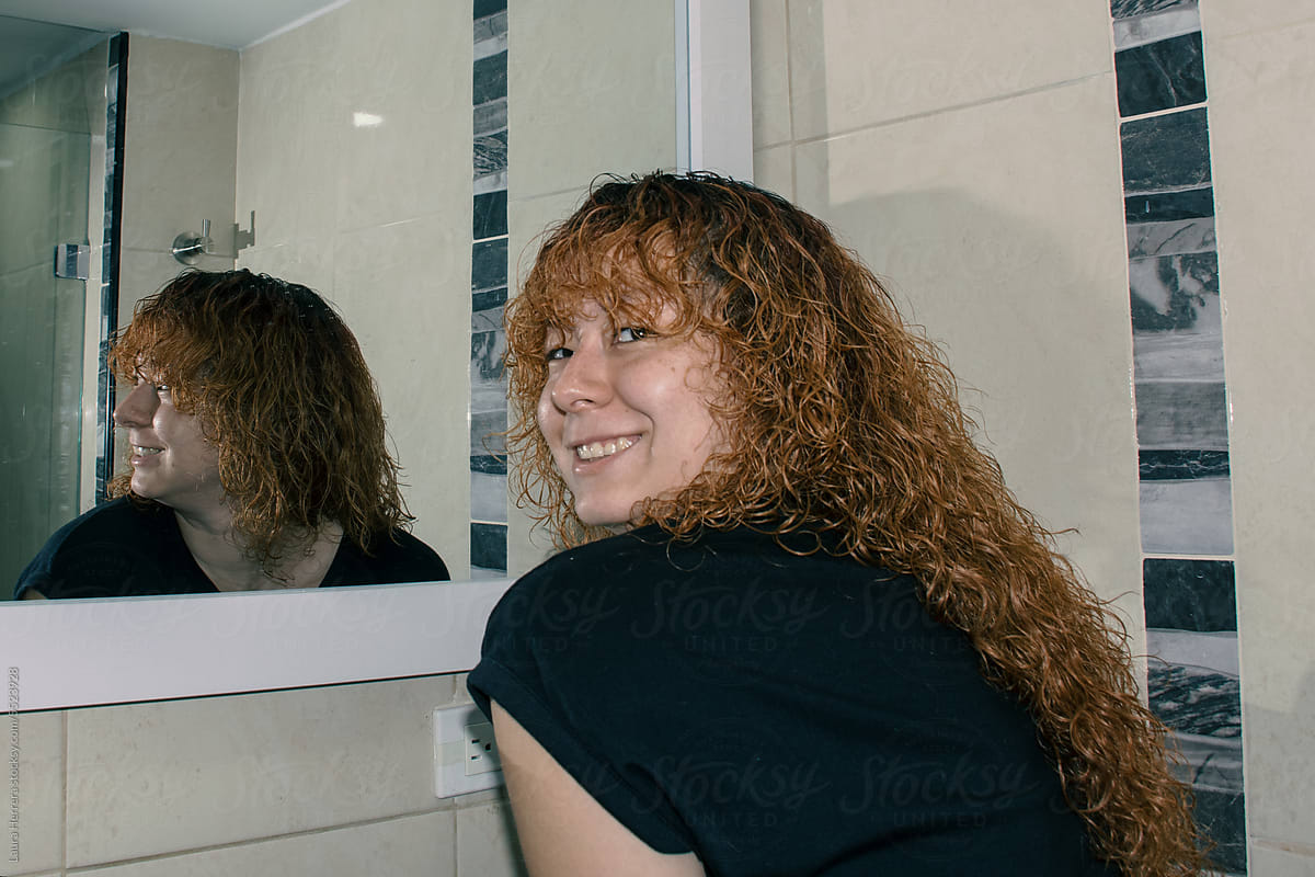 Woman looking at herself in the mirror and smiling