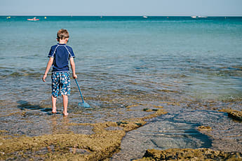 Child With Kids Fishing Net In The Sea by Stocksy Contributor